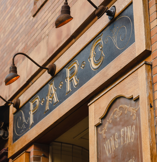 Vintage-style restaurant storefront with ornate sign reading "C.P.A.R.C." and decorative lights above.